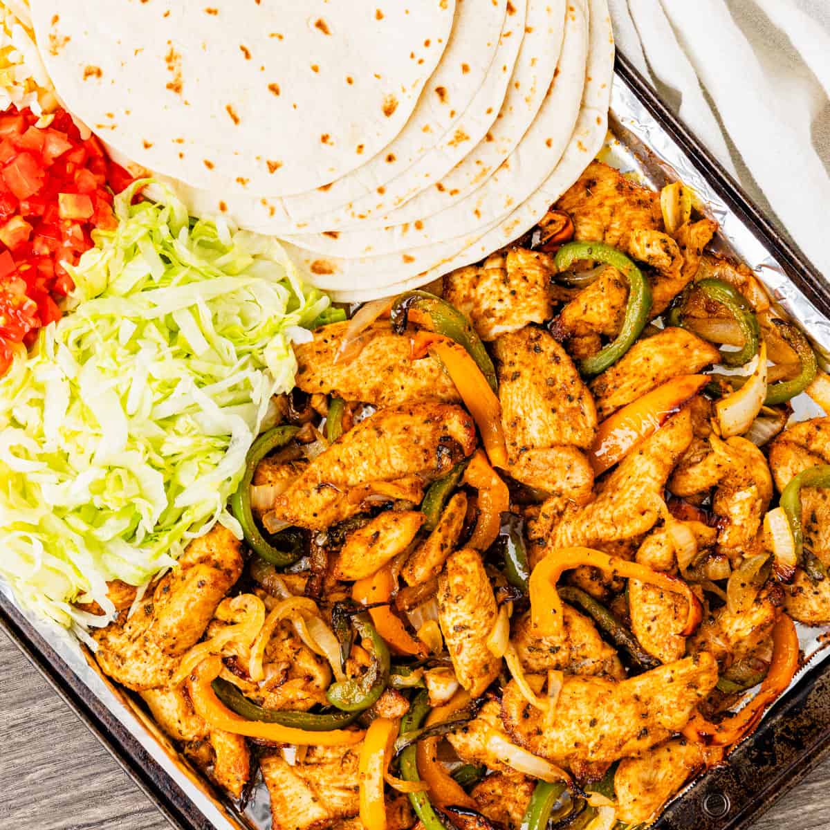 Chicken fajitas served with tortillas lettuce and tomatoes. 