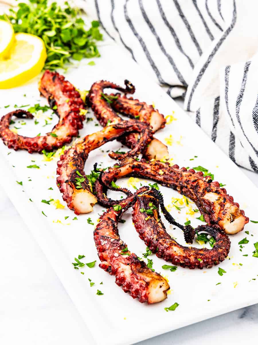 Grilled octopus legs on a platter.