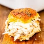 A chicken slider on a cutting board.