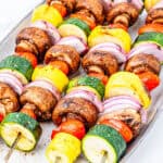 Vegetable kabobs on a platter.