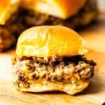 A cheeseburger slider set on a cutting board.