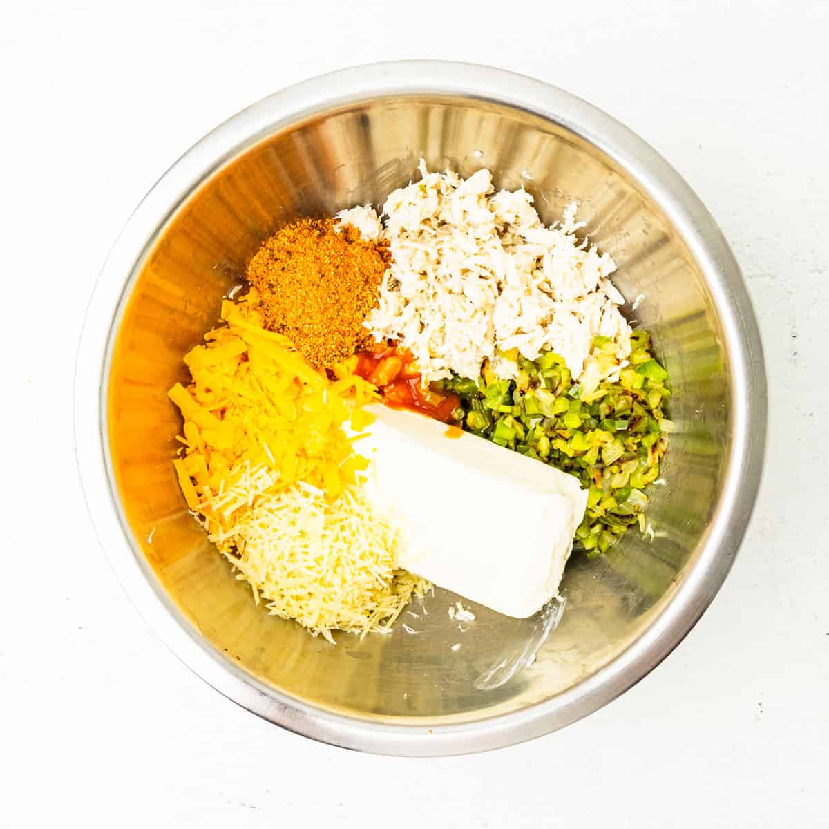 Ingredients for crab dip in a mixing bowl before being mixed.