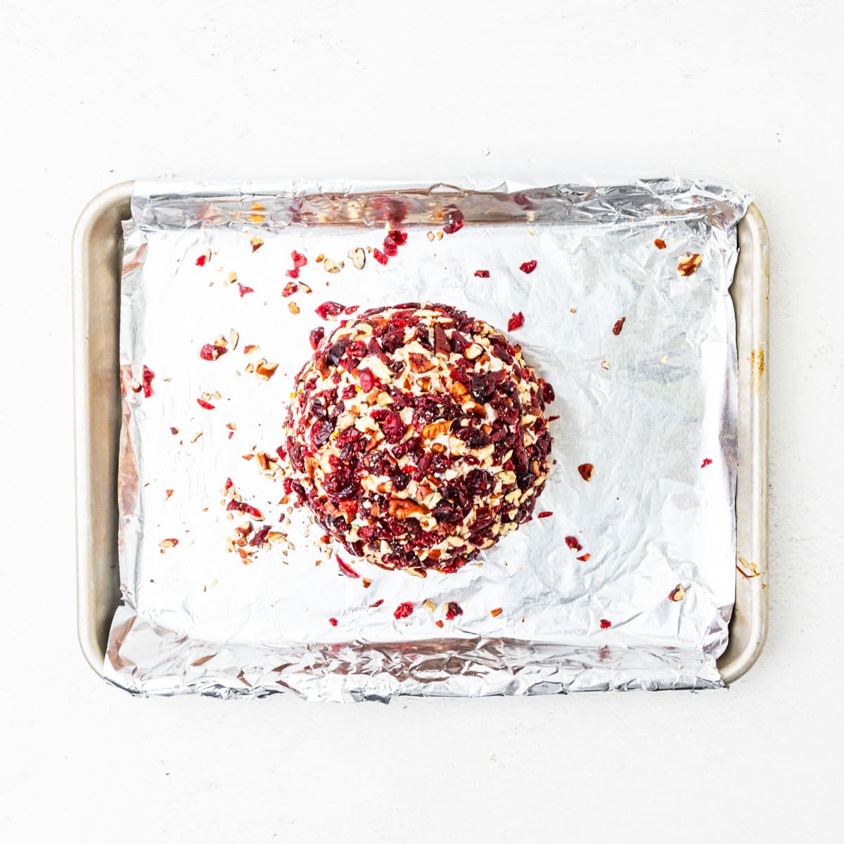 Cheese ball coated in chopped cranberries and pecans.