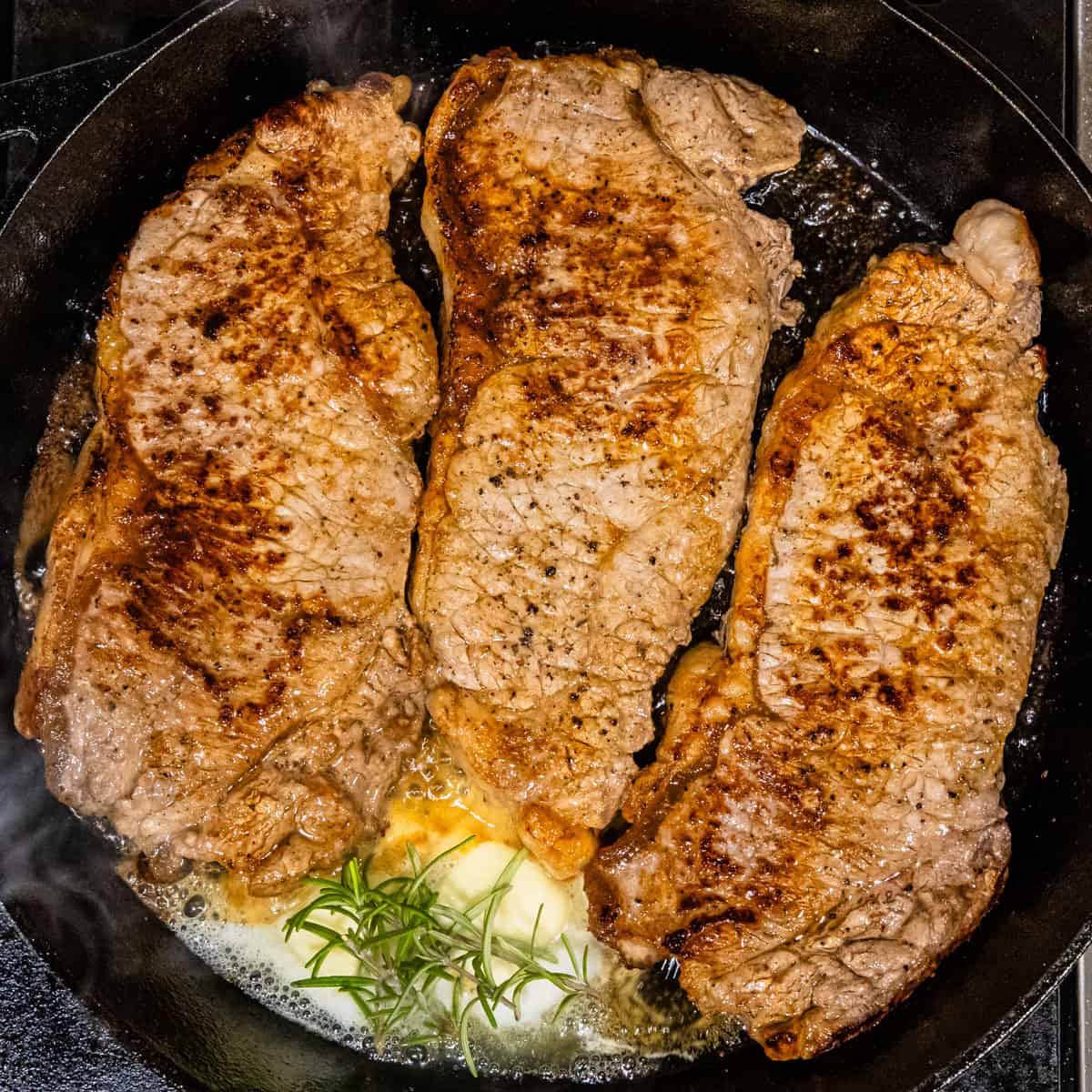 Seared steaks in a skillet.