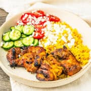 Chicken shawarma served with turmeric rice and veggies in a bowl.