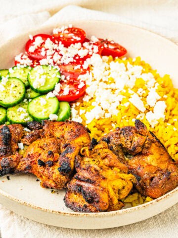 Chicken shawarma served with turmeric rice and veggies in a bowl.