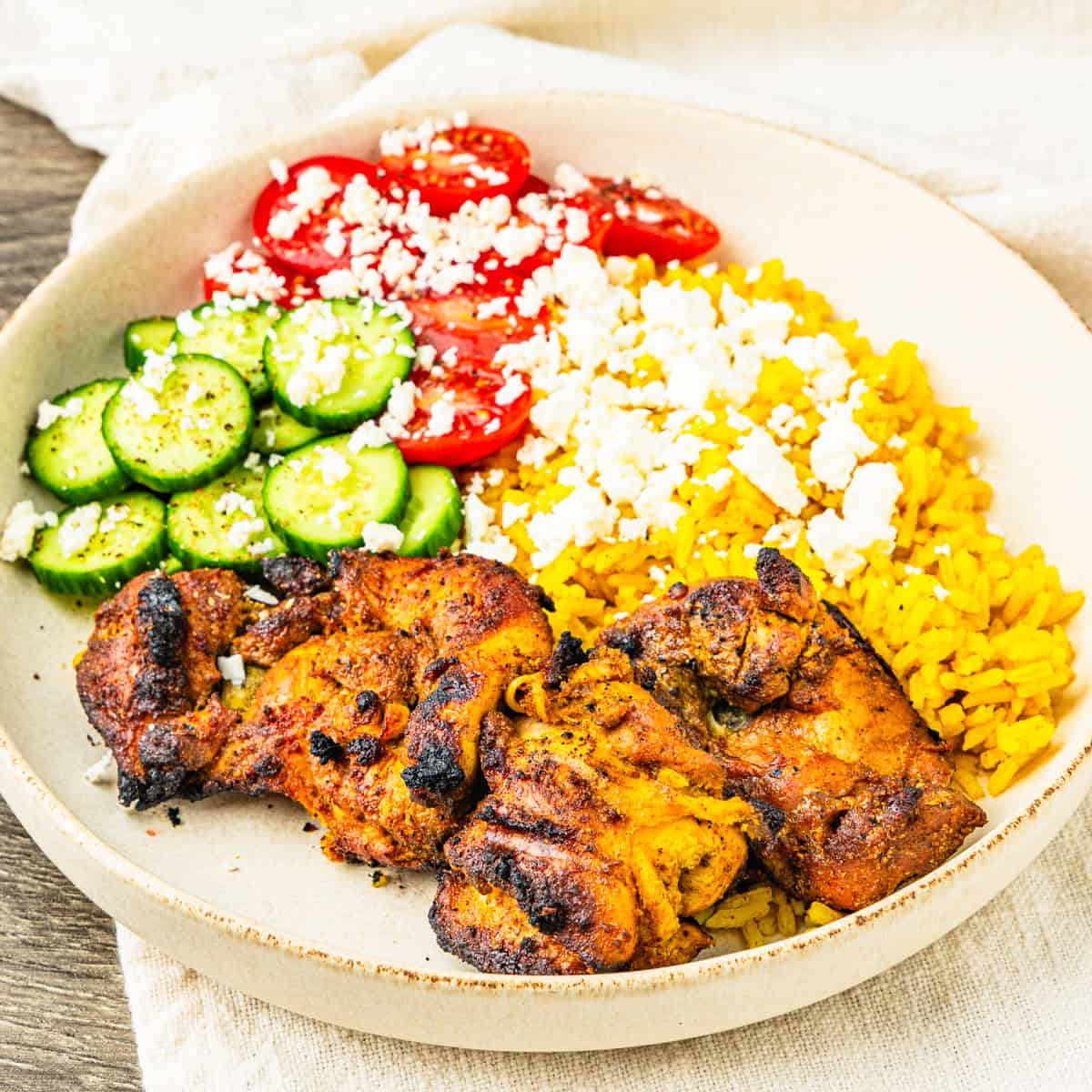 Chicken shawarma served with turmeric rice and veggies in a bowl.