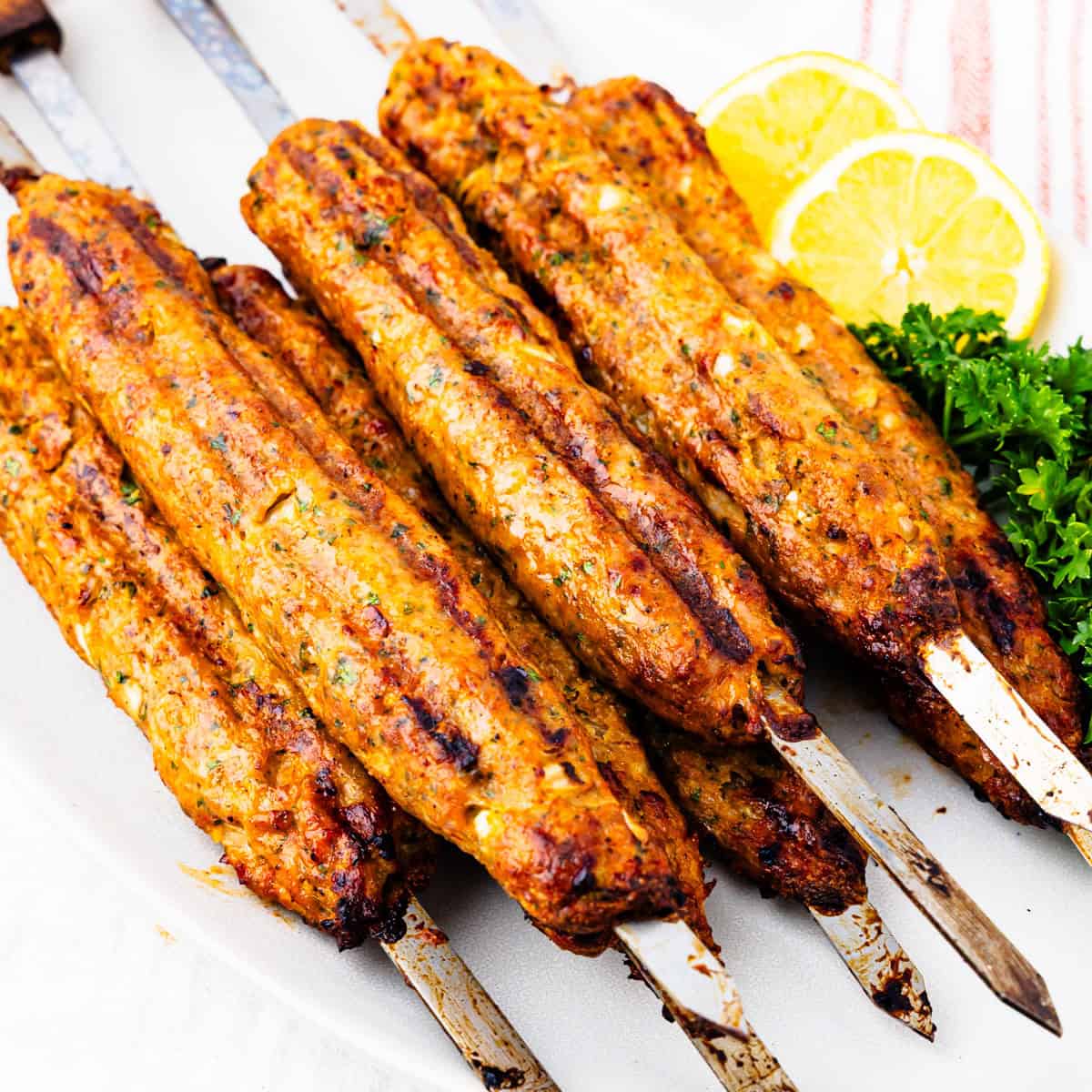 Grilled chicken kofta skewers on a platter.