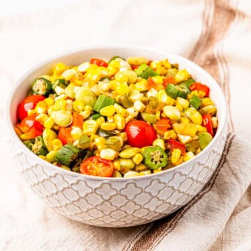A bowl of succotash made with corn, okra, lima beans, and tomatoes.