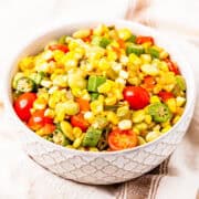 A bowl of succotash made with corn, okra, lima beans, and tomatoes.