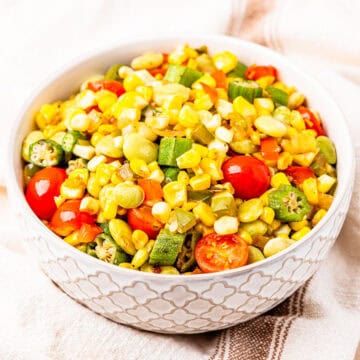 A bowl of succotash made with corn, okra, lima beans, and tomatoes.