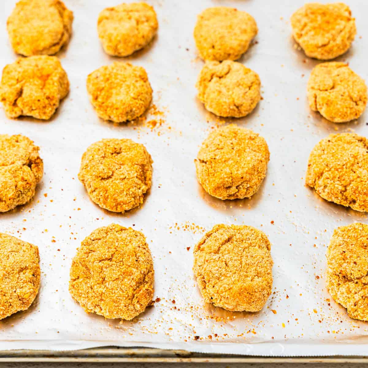 Cooked chicken nuggets on a baking sheet.