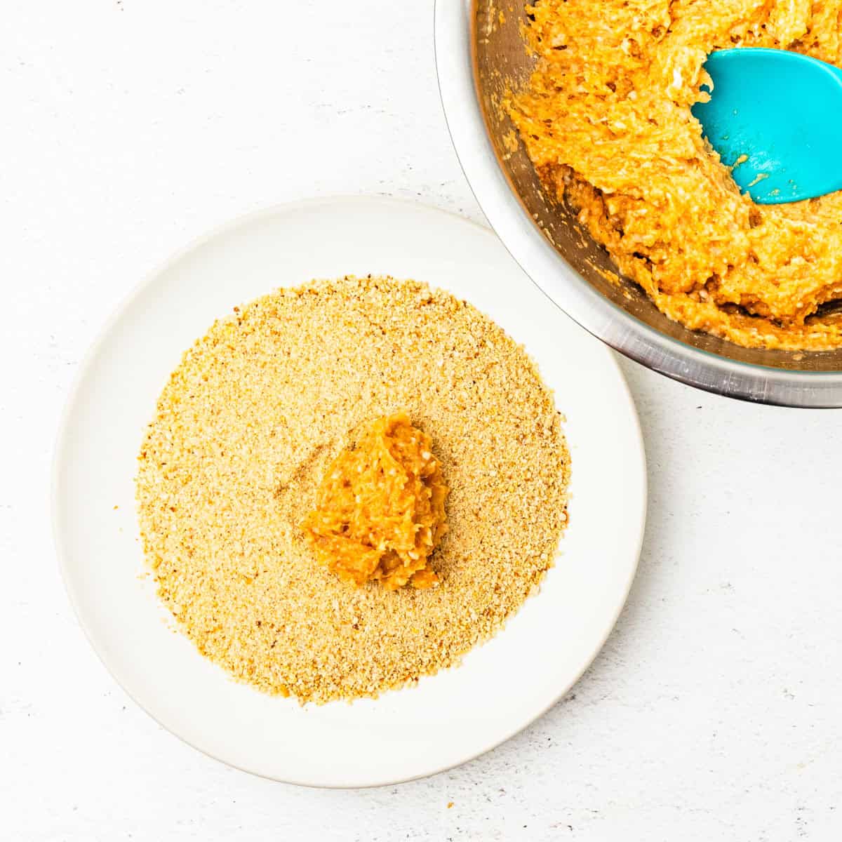 Chicken nuggets shown being breaded.