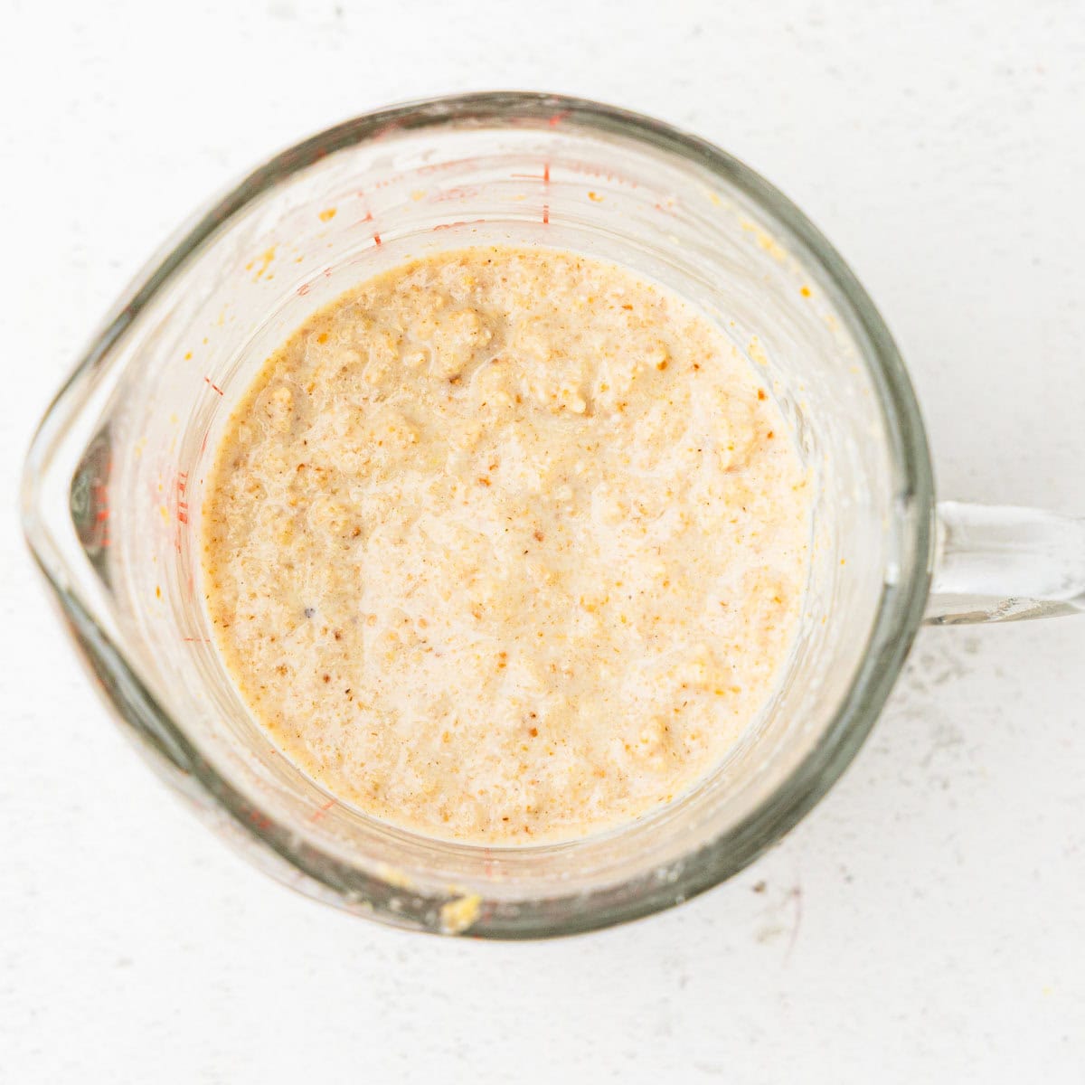 A milk and breadcrumb panade in a measuring cup.