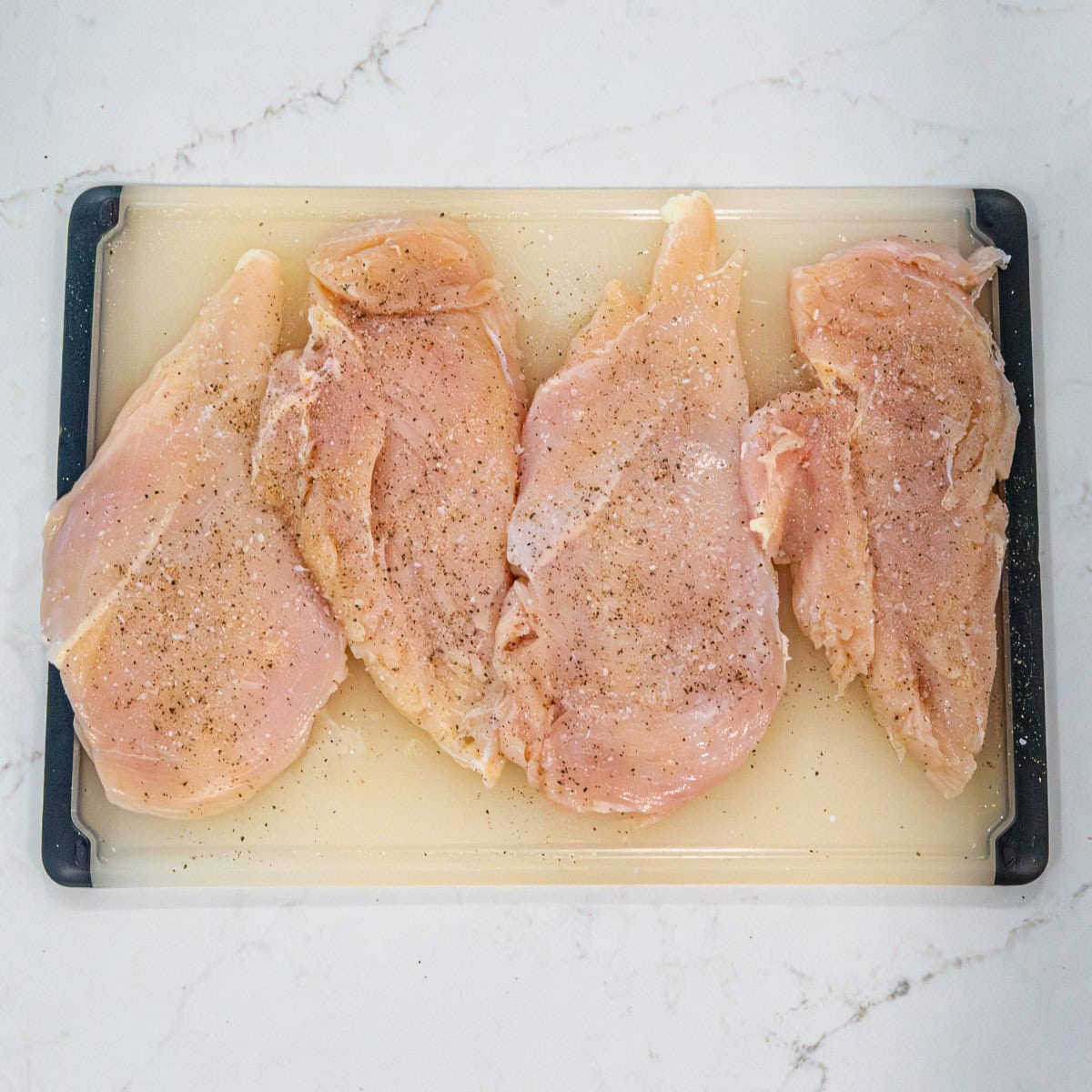 Chicken cutlets seasoned with salt and pepper.