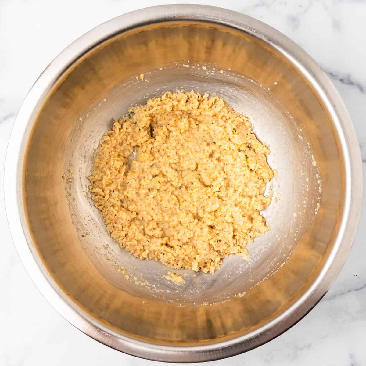 Breadcrumbs and milk mixed together in a mixing bowl.