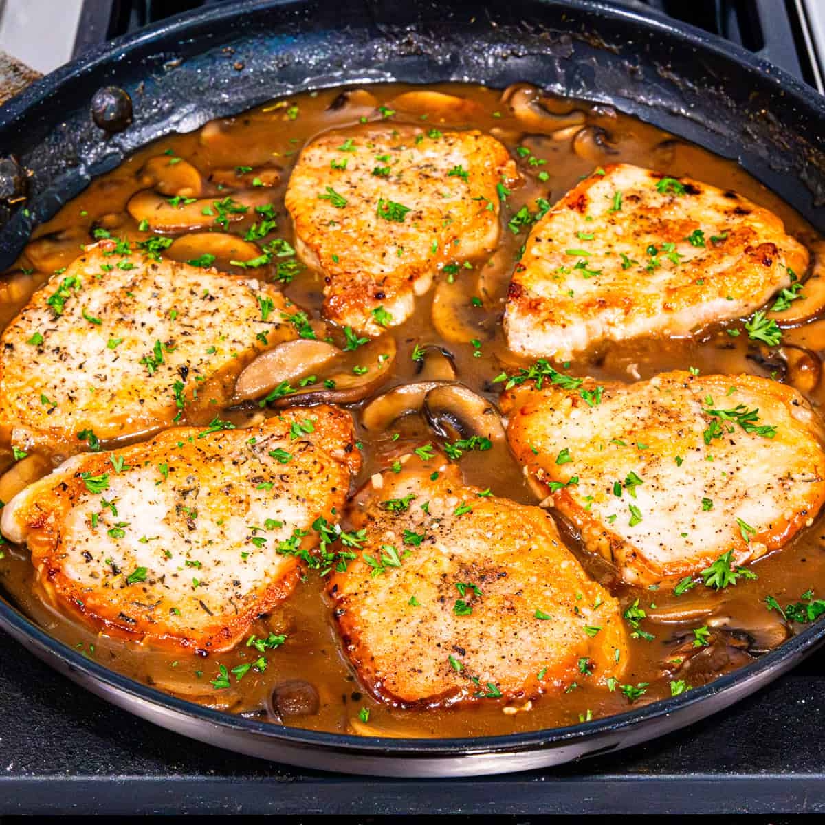 Pork chop marsala in a large skillet.