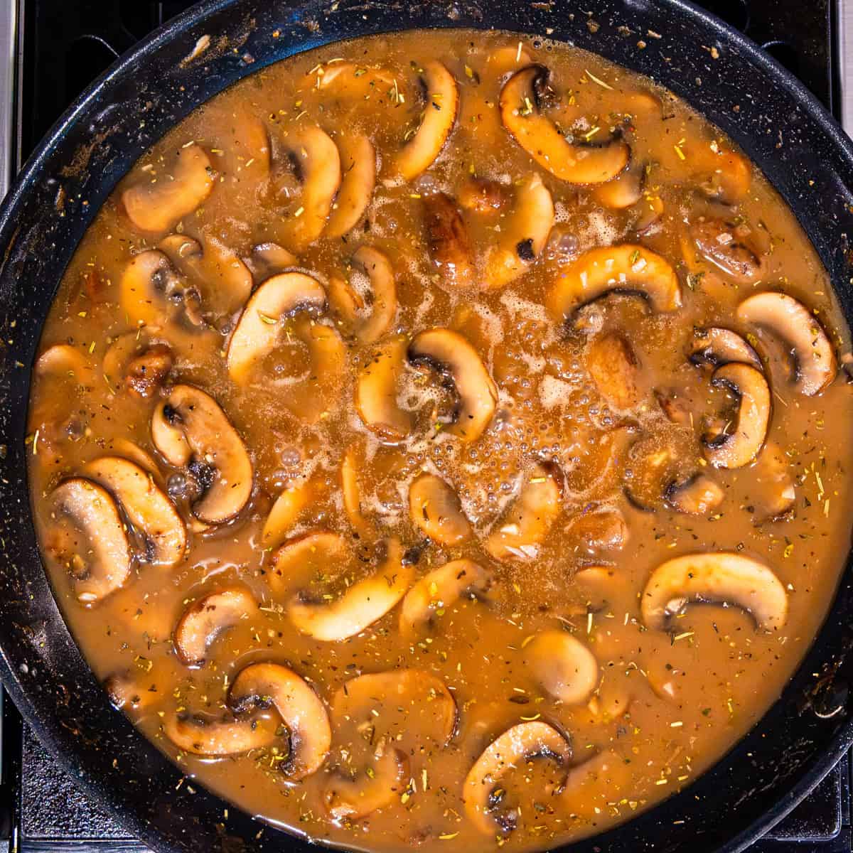 Mushrooms with marsala sauce in a pan.
