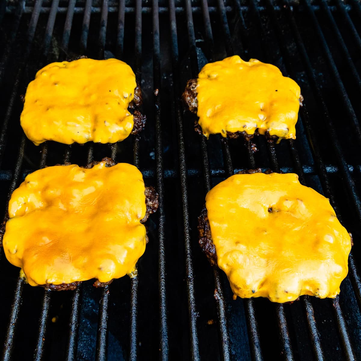Cheeseburgers on a grill.