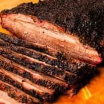 Smoked brisket flat sliced on a cutting board.