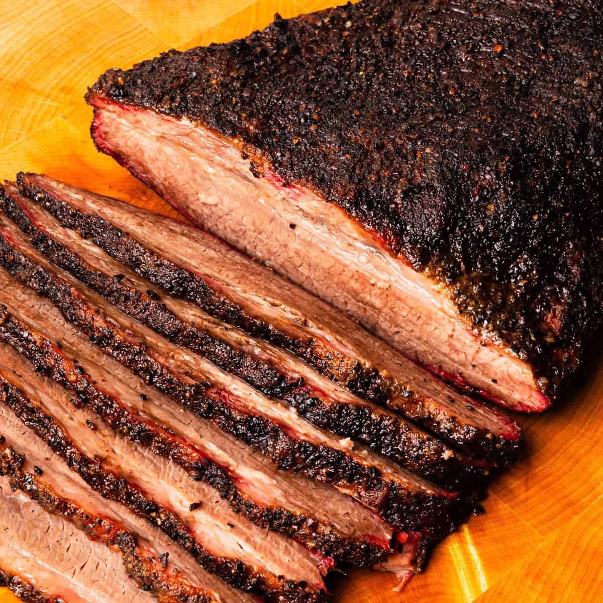 Smoked brisket flat sliced on a cutting board.