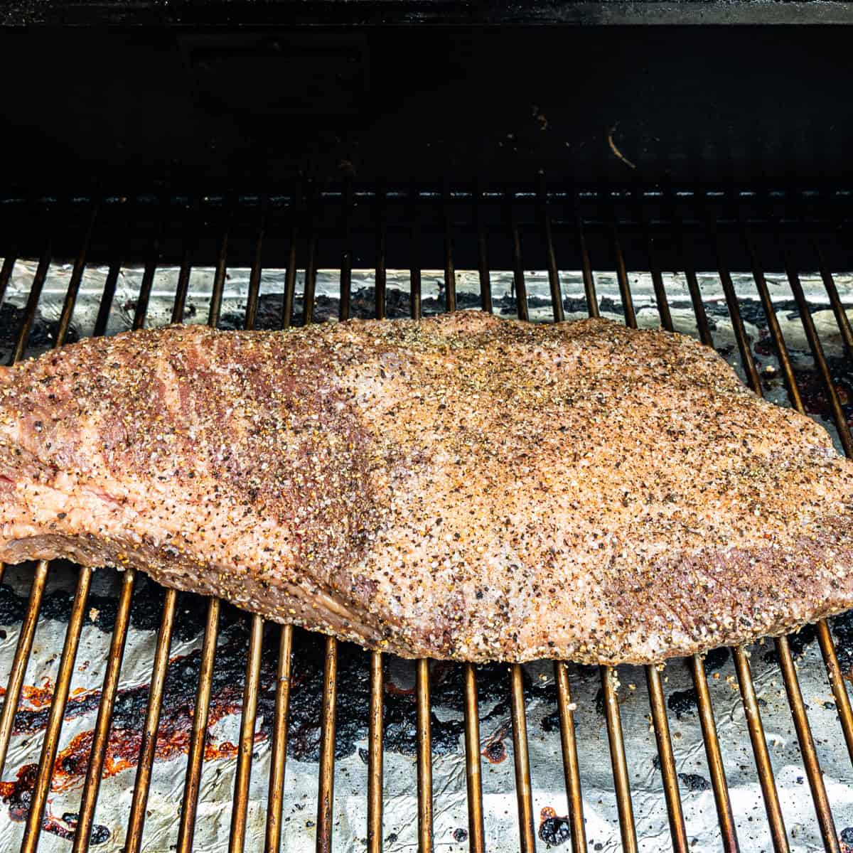 Uncooked brisket in a smoker.
