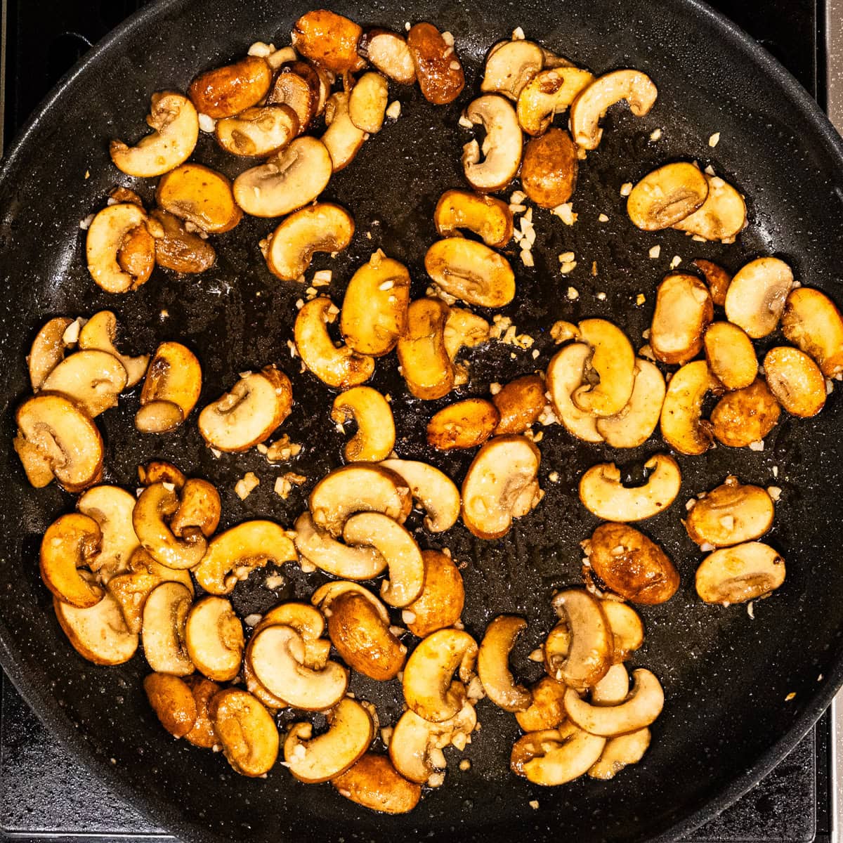 Mushrooms cooking in a skillet.