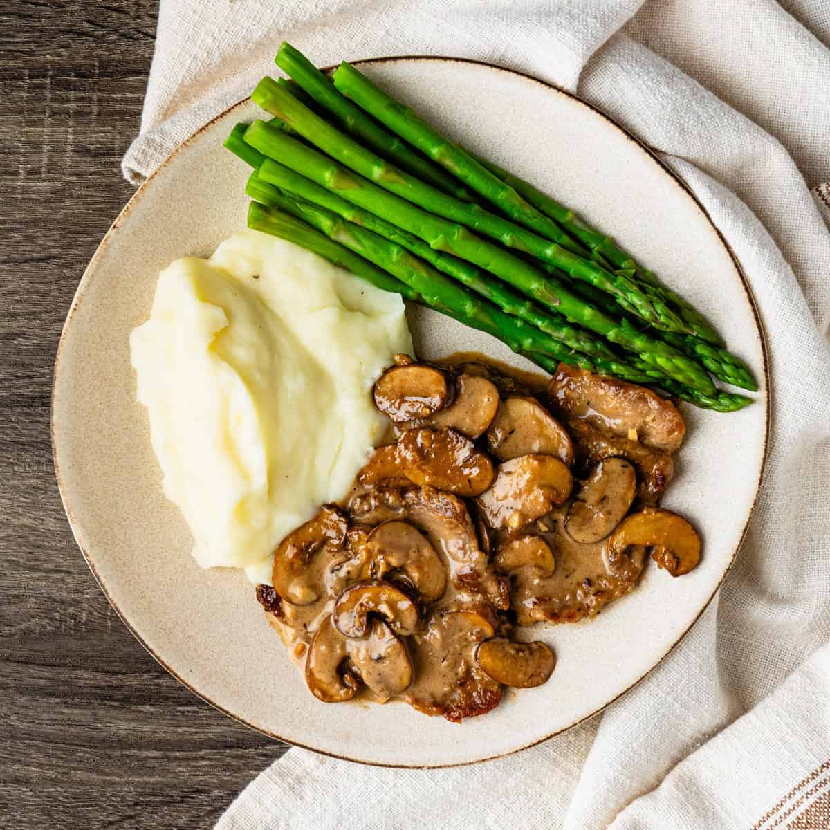 A plate of veal marsala with mashed potatoes.