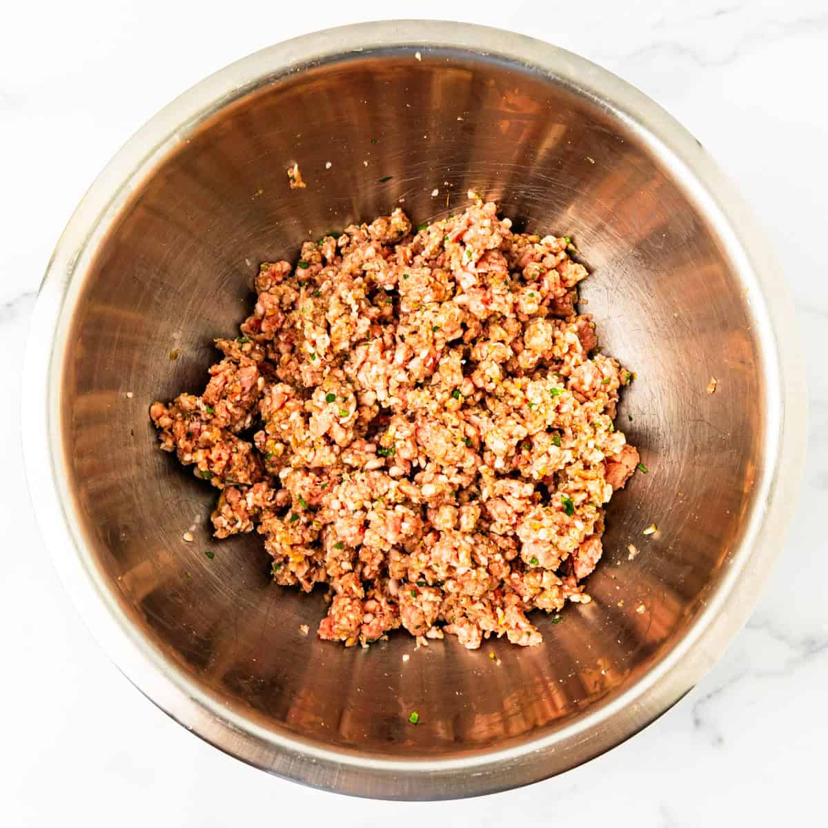 Ground lamb and spices mixed ina mixing bowl for lamb burgers.