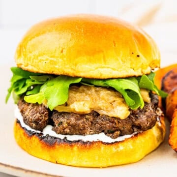 A lamb burger with caramelized onions and whipped feta sauce.