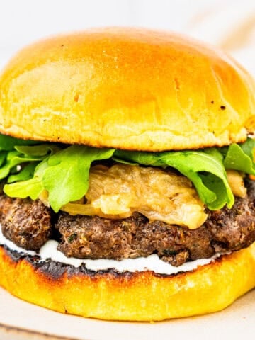 A lamb burger with caramelized onions and whipped feta sauce.