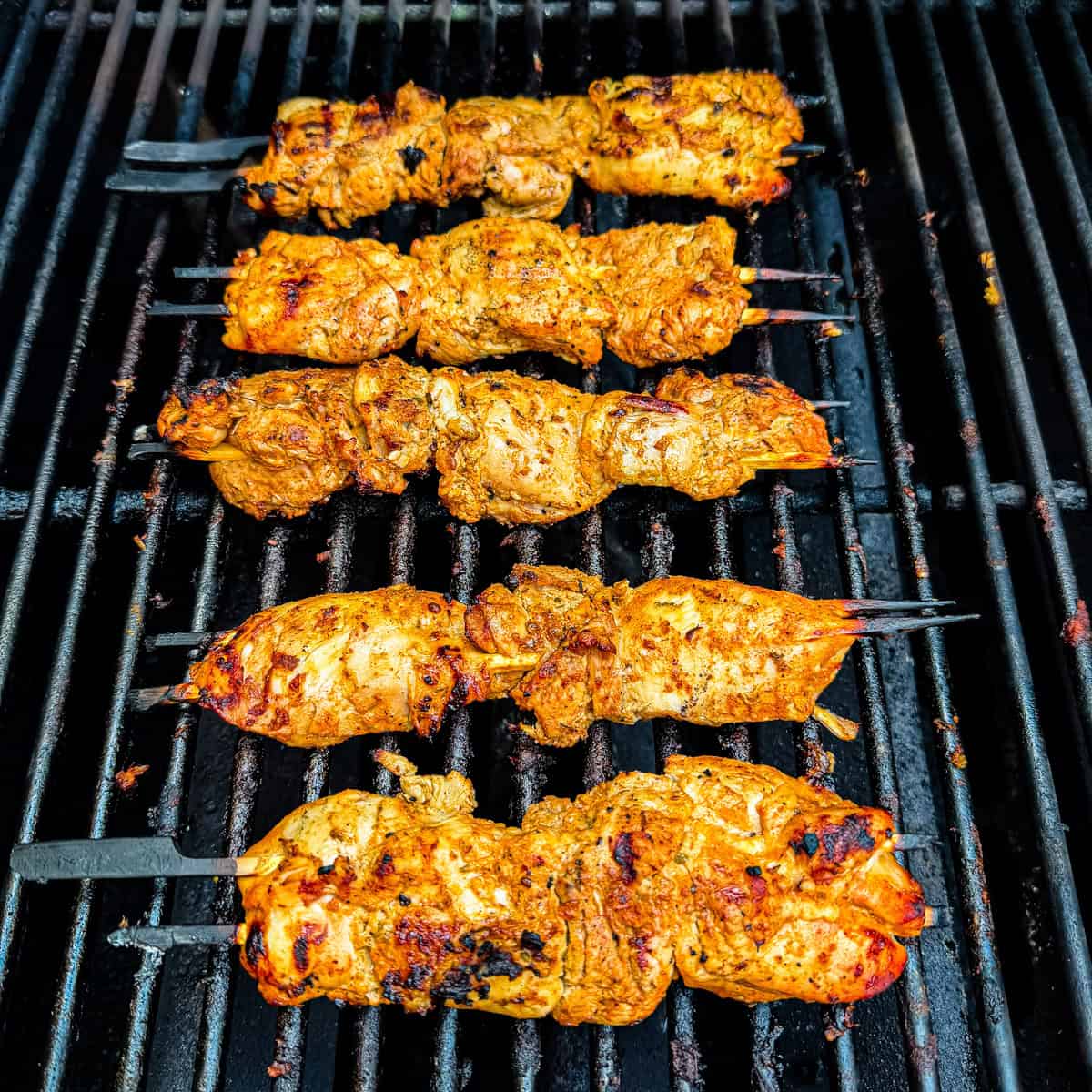 Finished chicken kabobs on a grill.