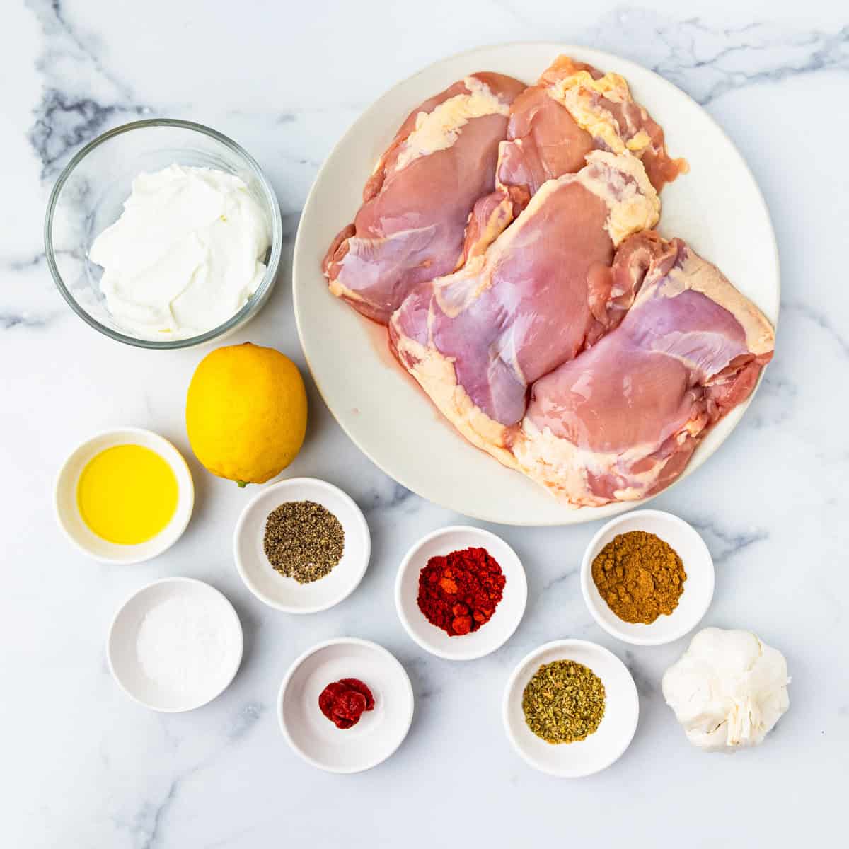 Ingredients for Mediterranean chicken kabobs arranged on a countertop.