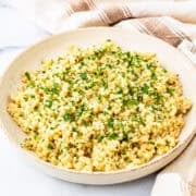 A bowl of lemon and herb couscous on a countertop.