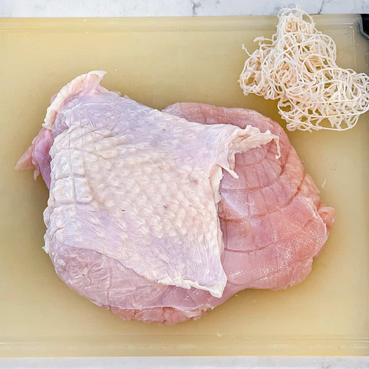 A boneless turkey breast on a cutting board.