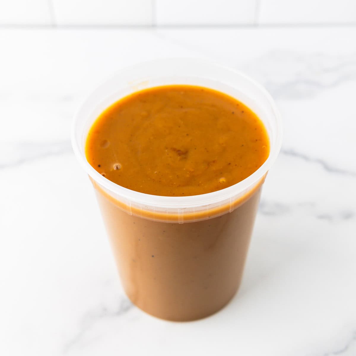 Turkey gravy in a plastic storage container.
